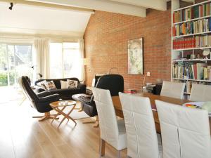 劳雷尔苏格Cosy holiday home in Lauwersoog的客厅配有桌椅和砖墙
