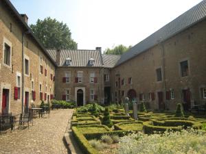 艾斯登Located 10km from Maastricht towards the Belgium border的一座带花园的古老建筑的庭院