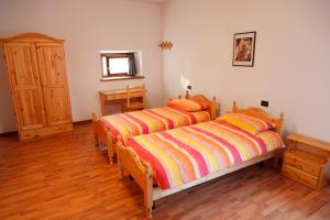 FannaSentiero Valinis的一间卧室设有两张床,铺有木地板