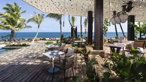 多拉多Residences at Dorado Beach, a Ritz Carlton Reserve的海滩上的餐厅,配有桌椅