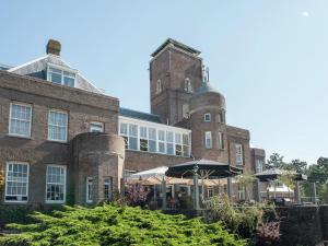 滨海贝亨Holiday Home in Bergen aan zee with Terrace的前面有一把伞的大砖砌建筑