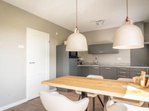 德科克斯多普fantastic bungalow on Texel的厨房配有木桌和白色椅子