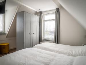 德科克斯多普fantastic bungalow on Texel的一间卧室设有两张床和窗户。