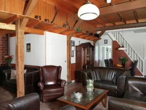 NeedeDetached farmhouse with play loft的客厅设有皮革家具和木制天花板。