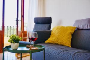 索列尔Alojamiento Migjorn - Apartaments tres Vents的一张沙发旁的桌子上放着一杯葡萄酒