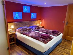 格洛博明Sonnenalm Mountain Lodge的卧室配有一张带蓝色灯光的墙壁床。