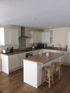 德斯利Hilltop Cottage的厨房配有白色橱柜和木制台面
