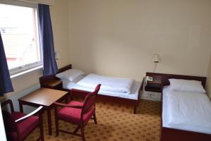 巴里斯川米缇恩斯酒店的酒店客房带两张床和一张桌子以及椅子。