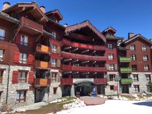 阿克1950Spacious ski-in ski-out apartment 4-6 pax, 161 Sources de Marie Arc 1950的一座大型建筑,设有红色的阳台