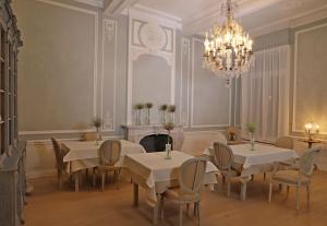 布鲁日米拉贝尔宾馆的一间带桌椅和吊灯的用餐室