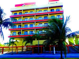 卡波布里奥Cobertura Climatizada, Spa no litoral的一座五颜六色的建筑,前面有棕榈树