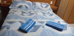 卡波布里奥Cobertura Climatizada, Spa no litoral的床上铺有蓝色枕头的床