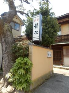 金泽金马醋民宿旅馆的树旁墙上的标志