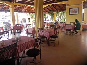 巴加滨江度假城 的一间设有桌椅的餐厅,以及坐在里面的人