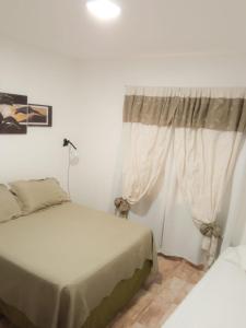 图努扬Departamentos Pachamama的一间卧室设有两张床和窗户。