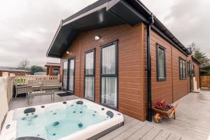 约克Lakeside View Lodge with Hot Tub的一座小房子,甲板上设有热水浴缸
