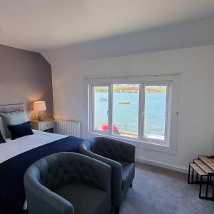 Isle of WhithornThe Steam Packet Inn的一间卧室配有一张床、一张沙发和一个窗口