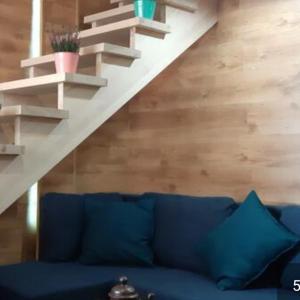 海乌姆诺Pokoj z antresolą的客厅设有蓝色沙发,设有楼梯