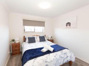 金德拜恩Jindalee 3 34 Twynam St的一间卧室配有蓝色和白色床单