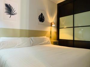托莱多Alda Suite de los Reyes的卧室配有白色的床和窗户。