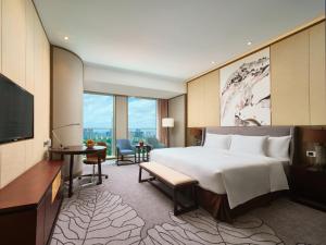 南宁南宁中心永恒皇冠假日酒店的一间酒店客房,配有一张大床和一台平面电视