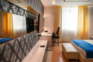 班加罗尔BNGV Mystic Premier Hotel的酒店客房配有一张床、一张书桌和一张书桌。