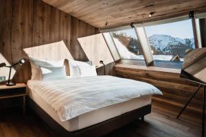 沃瑟姆阿尔伯格Berghotel Biberkopf的一间卧室设有一张床和一个大窗户