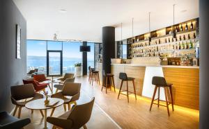 奥帕提亚Hotel Istra - Liburnia的一间带桌椅的餐厅和一间酒吧