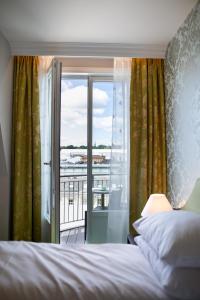奥斯陆松恩酒店的一间卧室设有一张床和一个阳台的窗户。