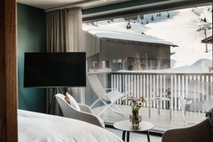 沃瑟姆阿尔伯格Berghotel Biberkopf的客房设有一张床和一个带电视的阳台