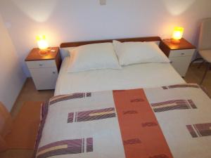 苏佩塔尔Apartments Croatia Brač的卧室配有2个床头柜,床顶上配有2把蜡烛