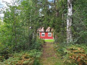 SvanesundTwo-Bedroom Holiday home in Svenshögen的森林中间的红色房子