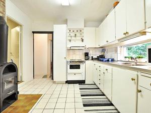 海斯勒霍尔姆5 person holiday home in H SSLEHOLM的厨房配有白色橱柜和炉灶。