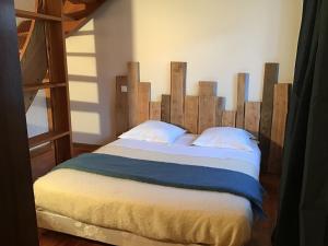 Fougax-et-BarrineufAu mohair des Alpy的一间卧室配有一张大床和木制床头板