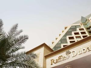迪拜迪拜莱福士酒店的前面有棕榈树的建筑