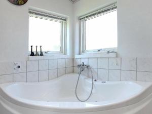 伦斯楚普8 person holiday home in Hj rring的带2扇窗户的浴室内的白色浴缸