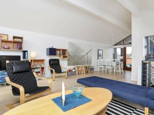 博恩瑟6 person holiday home in Bogense的客厅配有蓝色的沙发和桌子