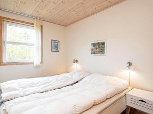 莱斯Holiday home Læsø XXIV的窗户客房内的一张大白色床