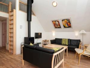 孔斯马克Three-Bedroom Holiday home in Rømø 5的客厅配有黑色沙发和壁炉