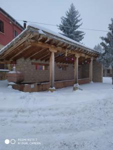 AlcorochesHotel Herranz的地面上有雪的木制凉亭