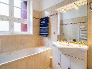 比亚里茨Apartment la République-1 by Interhome的浴室配有盥洗盆、浴缸和镜子
