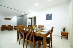 海得拉巴Skyla Serviced Apartments的一间带木桌和椅子的用餐室