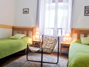 比亚里茨Apartment Goélands by Interhome的一间卧室设有两张床、一把椅子和一个窗户。