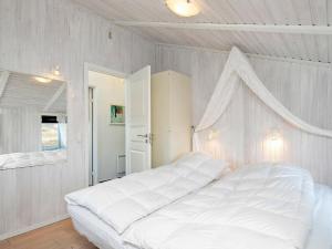 灵克宾Holiday home Ringkøbing XVII的白色卧室配有一张白色的大床