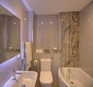 多尔金Denbies Vineyard Hotel的浴室配有卫生间、浴缸和水槽。
