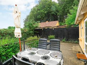 Refshammer4 person holiday home in Nyk bing M的露台配有遮阳伞和桌椅