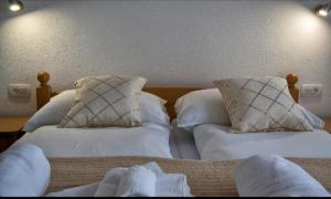 塞里特雷尼科Apartment Josipa的卧室内的两张床,配有白色床单和枕头