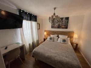 瓦尔堡白雪酒店的一间卧室配有一张床、一张书桌和一台电视