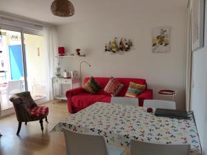 卡布勒通Appartement Pour 4 Personnes Avec Vue Sur Le Port De Plaisance- Residence Le Genois的客厅配有桌子和红色沙发