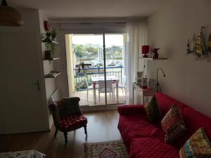 卡布勒通Appartement Pour 4 Personnes Avec Vue Sur Le Port De Plaisance- Residence Le Genois的一间带红色沙发的客厅和一个阳台